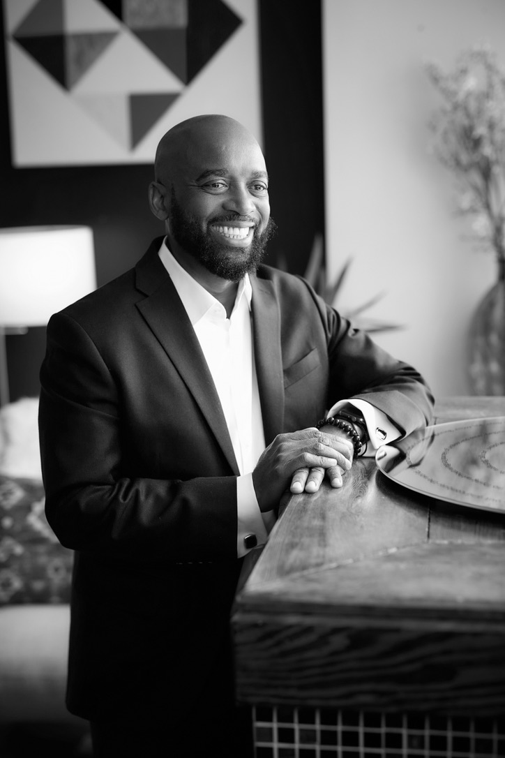 Black-and-white portrait of MuRay (Courtney A. Kazembe) at a piano